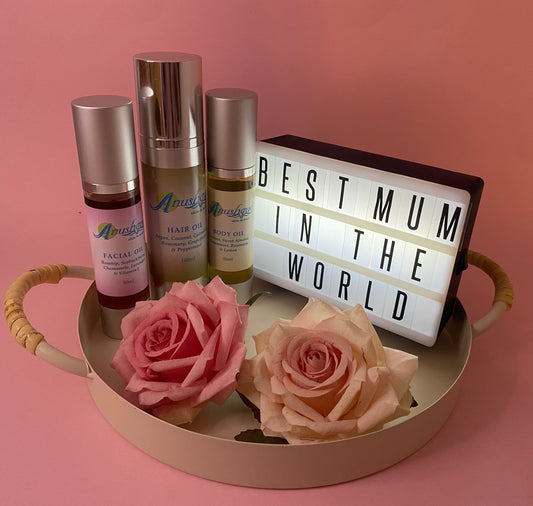 Basket containing a bottle of facial oil, a bottle of hair oil, and a bottle of body oil.